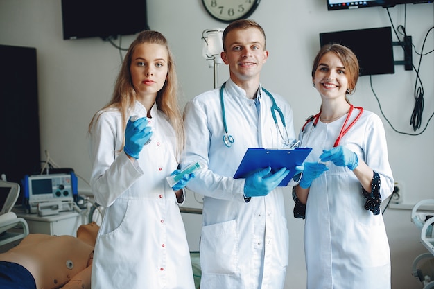 Men and women in hospital gowns hold medical equipment in their hands. 