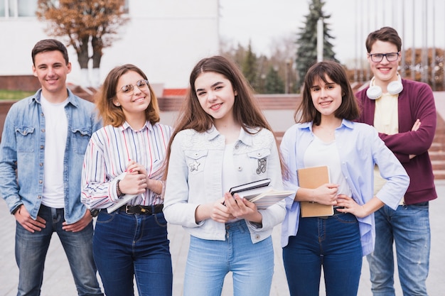 Free photo men and women standing with books looking at camera