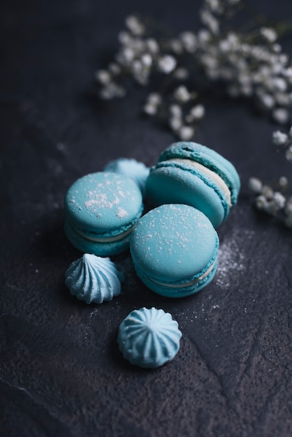 Free photo merengue with stacked of blue macaroon on textured background