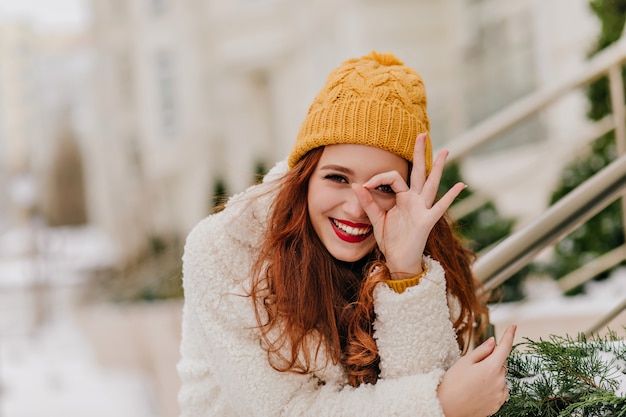 Free photo merry female model having fun in winter. pleased caucasian ginger woman laughing on nature.