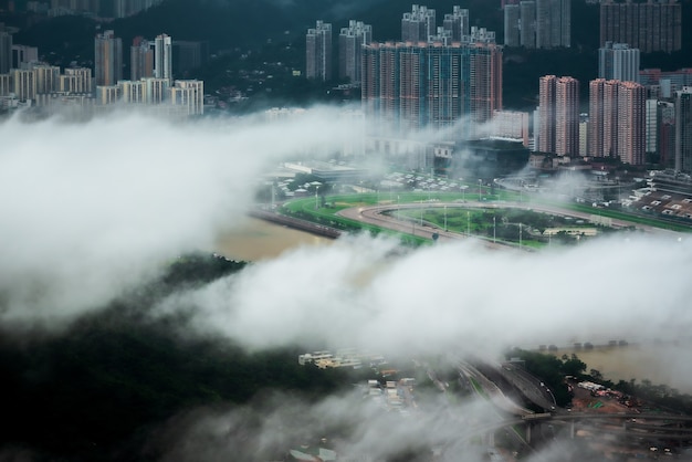 Free photo mesmerizing aerial view of hong kong city through the clouds