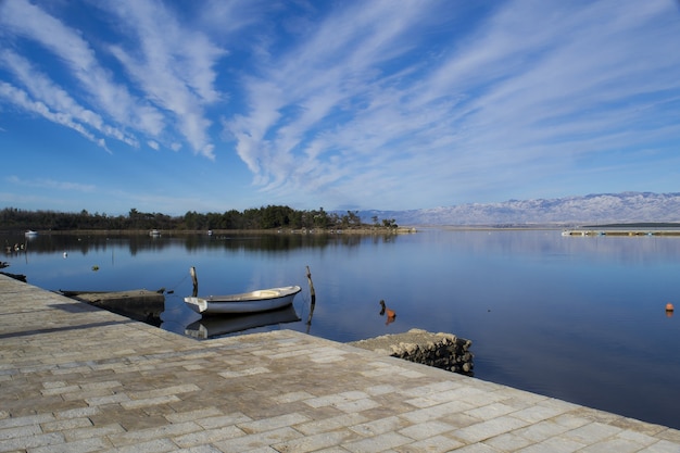 Free photo mesmerizing  panoramic shot of a large lake under a blue sky with streams of clouds