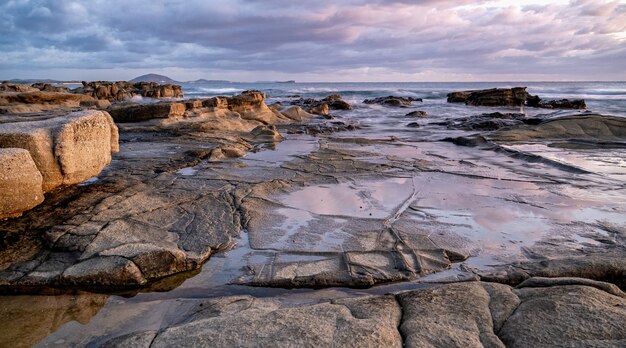 Mesmerizing shot of a rocky shore at the sunset