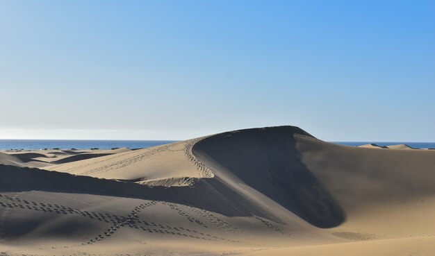 Mesmerizing shot of sand dunes against a blue sky in Gran Canaria, Spain