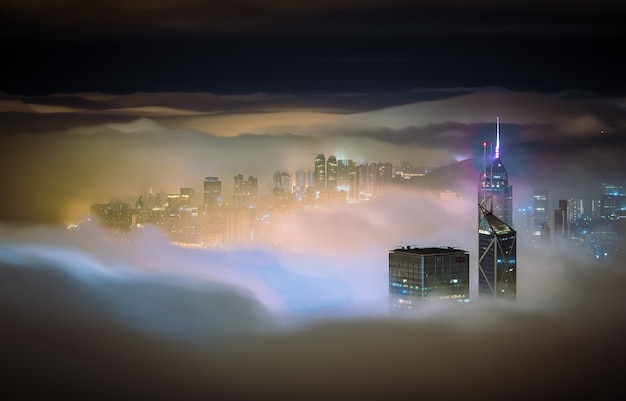 Free Photo mesmerizing shot of the skyscrapers of a city covered in mist at night