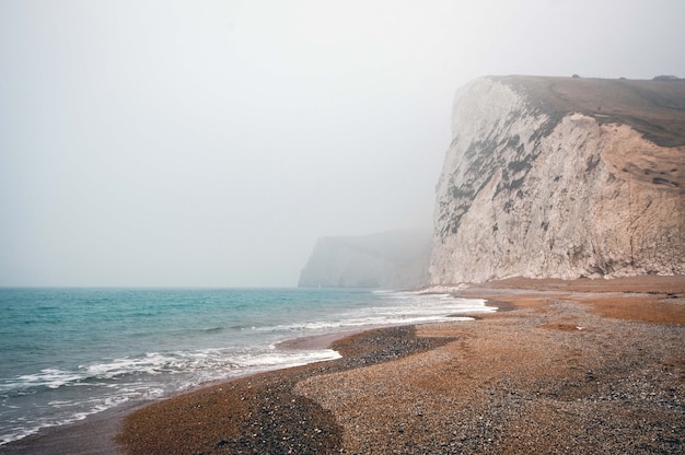 Mesmerizing view of the calm ocean on a foggy day in Purbeck Heritage Coast Swanage UK