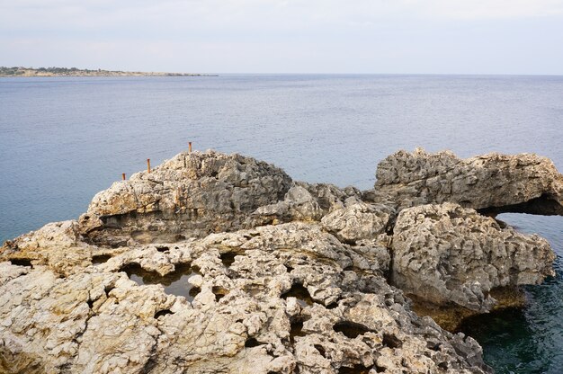 Mesmerizing view of the cliff on the shore of an ocean under the blue sky