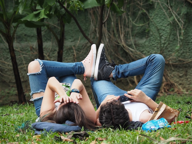 Free photo mesmerizing view of a lovely couple lying on the grass in the forest