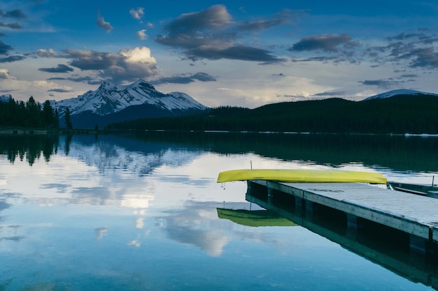 Free Photo mesmerizing view of the pier near the lake surrounded by lush nature and the mountains