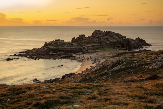 Free photo mesmerizing view of the shore of the calm ocean during sunset in galicia, spain