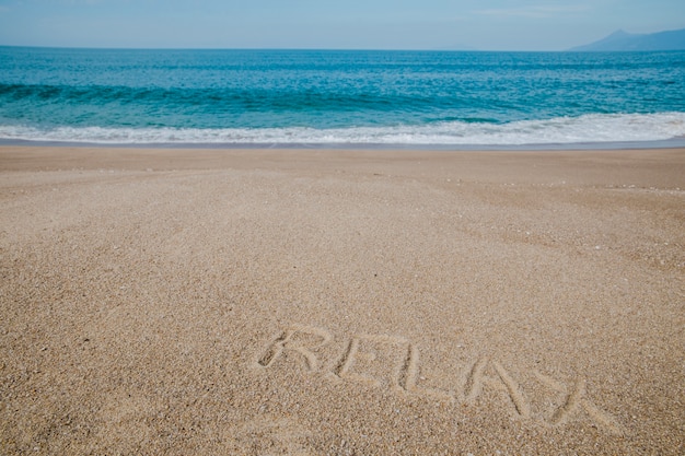 Free Photo message on sand saying to relax