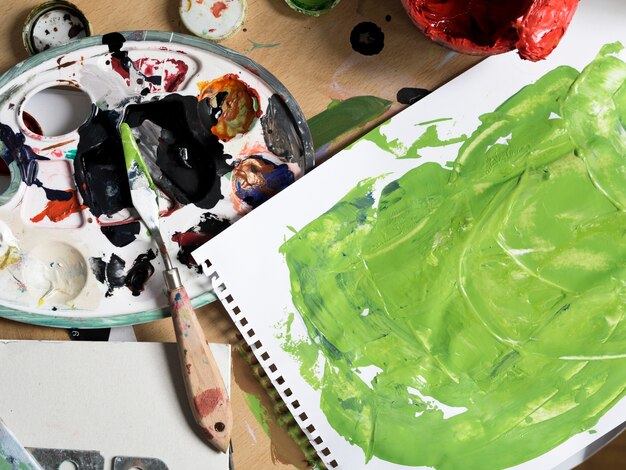 Messy painting tools next to green painting