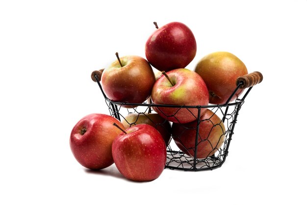 Metal basket of fresh ripe apples isolated on white.