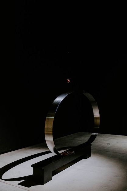 Metal circle in front of a black wall