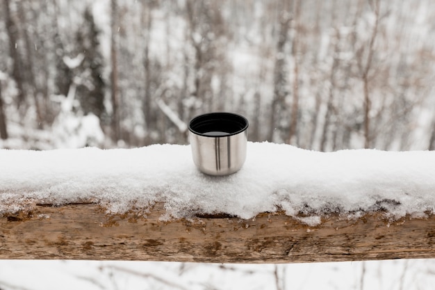 Metal cup in winter forest