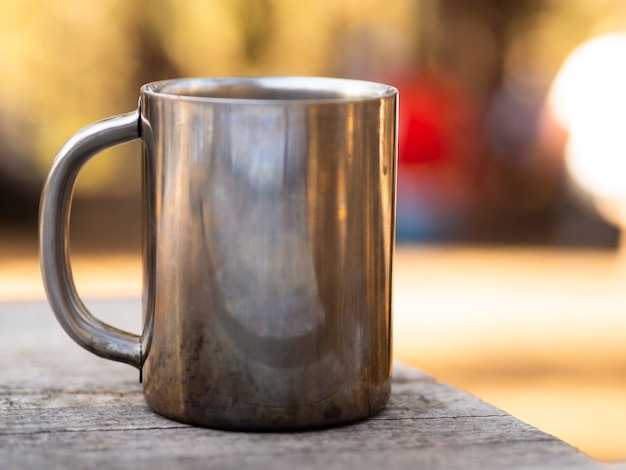 Free Photo metal mug with glare on shabby wooden table