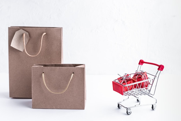 Free photo metal trolley with gifts and shopping bags on a white