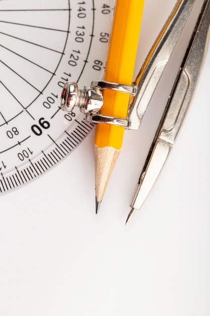 Free photo metallic drawing compass isolated with pencil on white wall