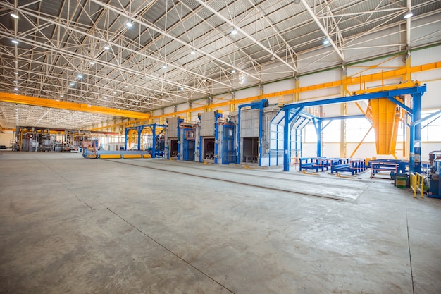 Metallic ovens inside a big factory with heavy equipments. 