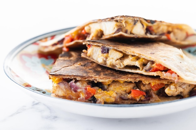 Free Photo mexican chicken quesadillas with cheese and peppers on white marble