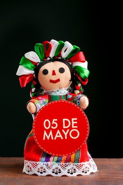 Mexican doll holding 5th of may sign