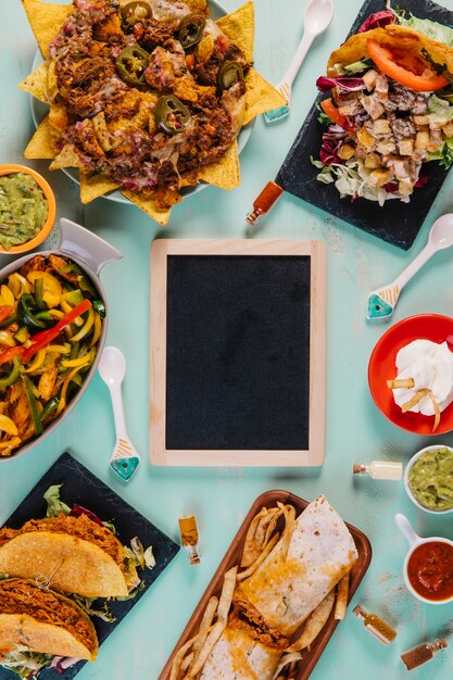 Mexican food and blackboard on blue background