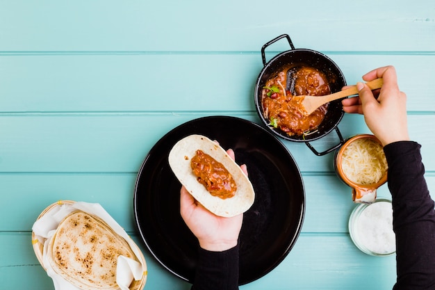 Free photo mexican food concept with hands preparing burrito