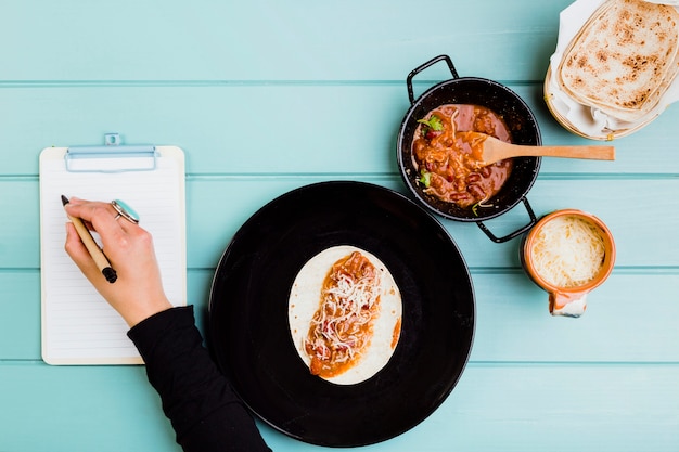 Free Photo mexican food concept with hands preparing burrito