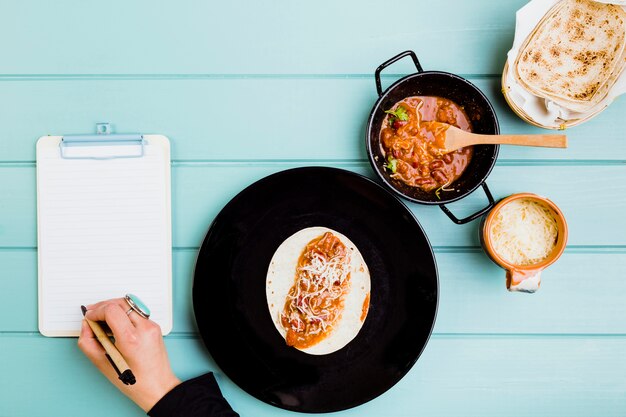 Mexican food concept with hands preparing burrito