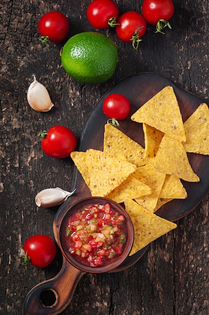 Free photo mexican nacho chips and salsa dip in bowl on wooden