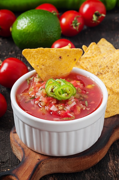 Mexican nacho chips and salsa dip in  bowl 