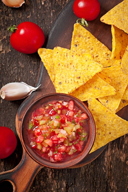 Mexican nacho chips and salsa dip in  bowl 