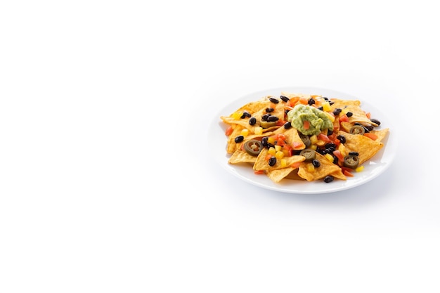 Mexican nachos tortilla chips with black beans, guacamole, tomato and jalapeno isolated on white background