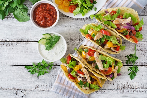 Mexican tacos with chicken, bell peppers, black beans and fresh vegetables