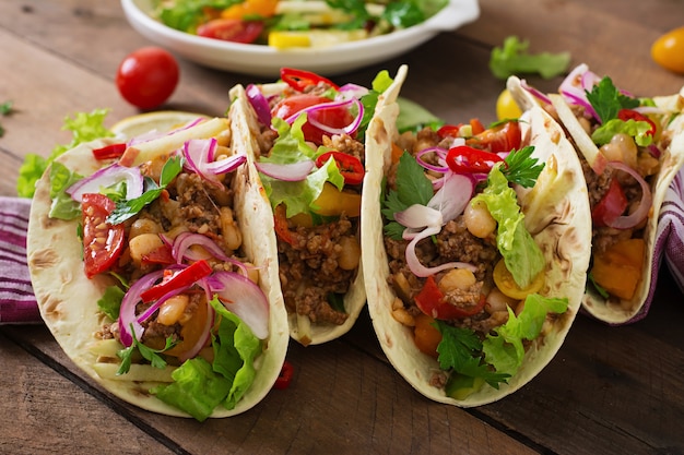 Free photo mexican tacos with meat, beans and salsa