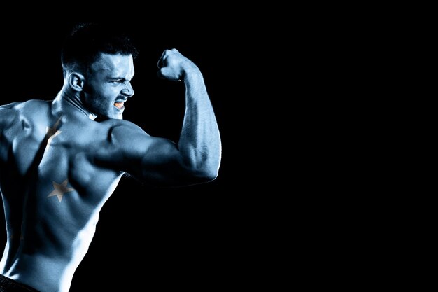 Micronesia flag on handsome young muscular man black background