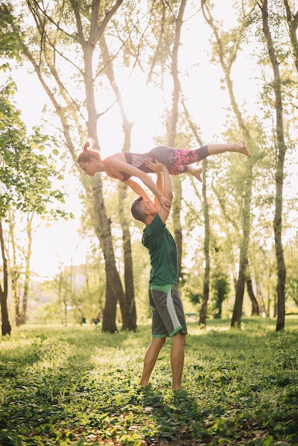 Mid adult couple using acrobatic tricks in park