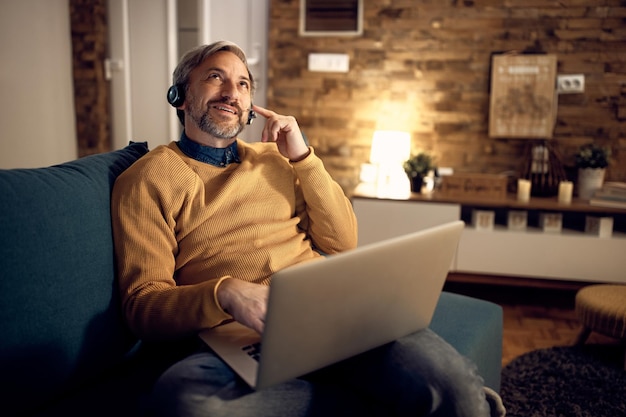 Free Photo mid adult entrepreneur talking during video call from home at night