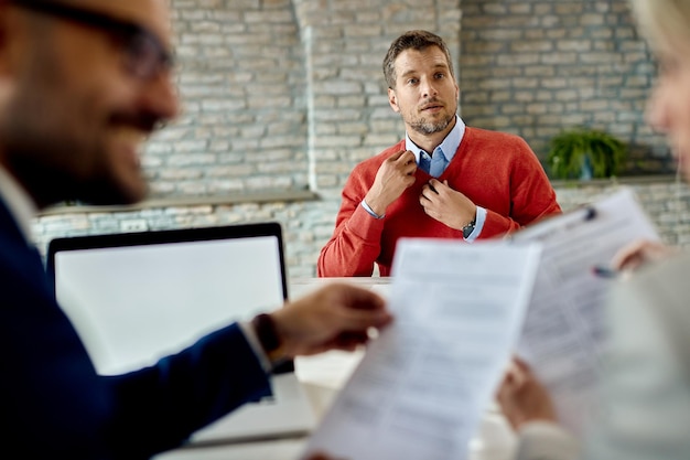 Free photo mid adult man applying for job and waiting for human resource team to review his resume in the office