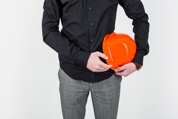 Mid section of an architect holding orange clipboard over white backdrop