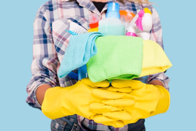 Free Photo mid section of cleaner holding bucket with cleaning products wearing yellow gloves