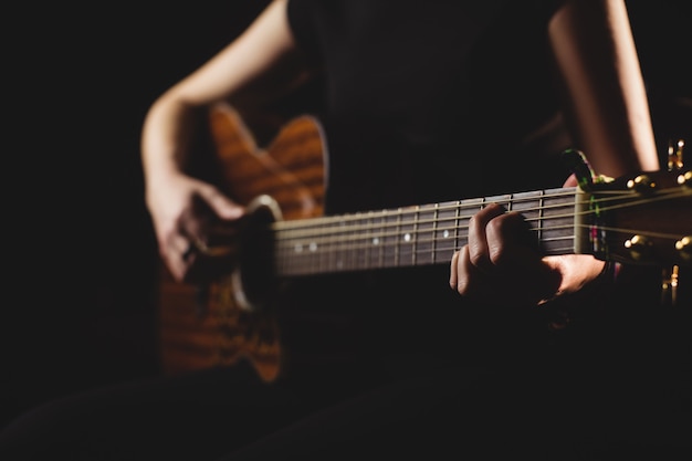 Mid-section female student playing guitar