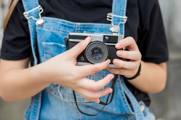 Free Photo mid section of girl hand adjusting lens of retro camera