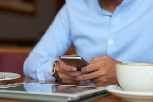 Mid section of man reading news online having coffee