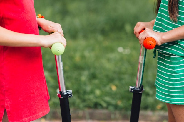 Mid section of two female friends with push scooter