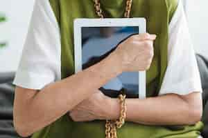 Free photo mid section of woman holding digital tablet