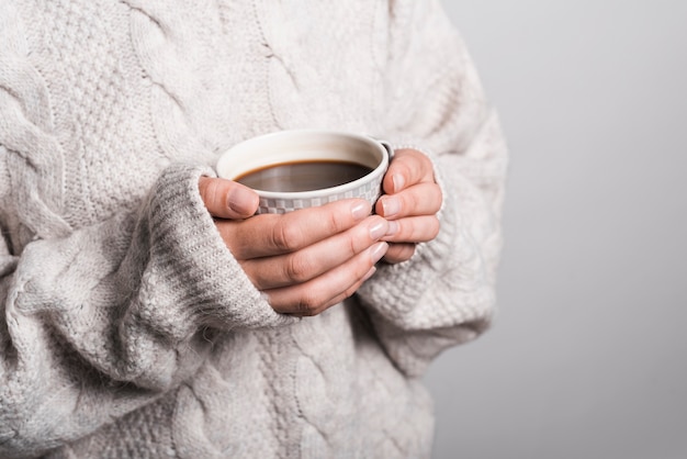 Free Photo mid section of woman in woolen clothes holding coffee cup