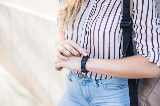 Free Photo mid section of young woman checking time on digital watch