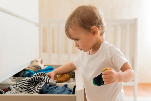 Mid shot baby searching in drawer