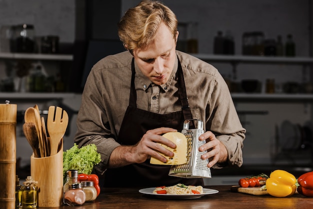 Free photo mid shot chef grating cheese